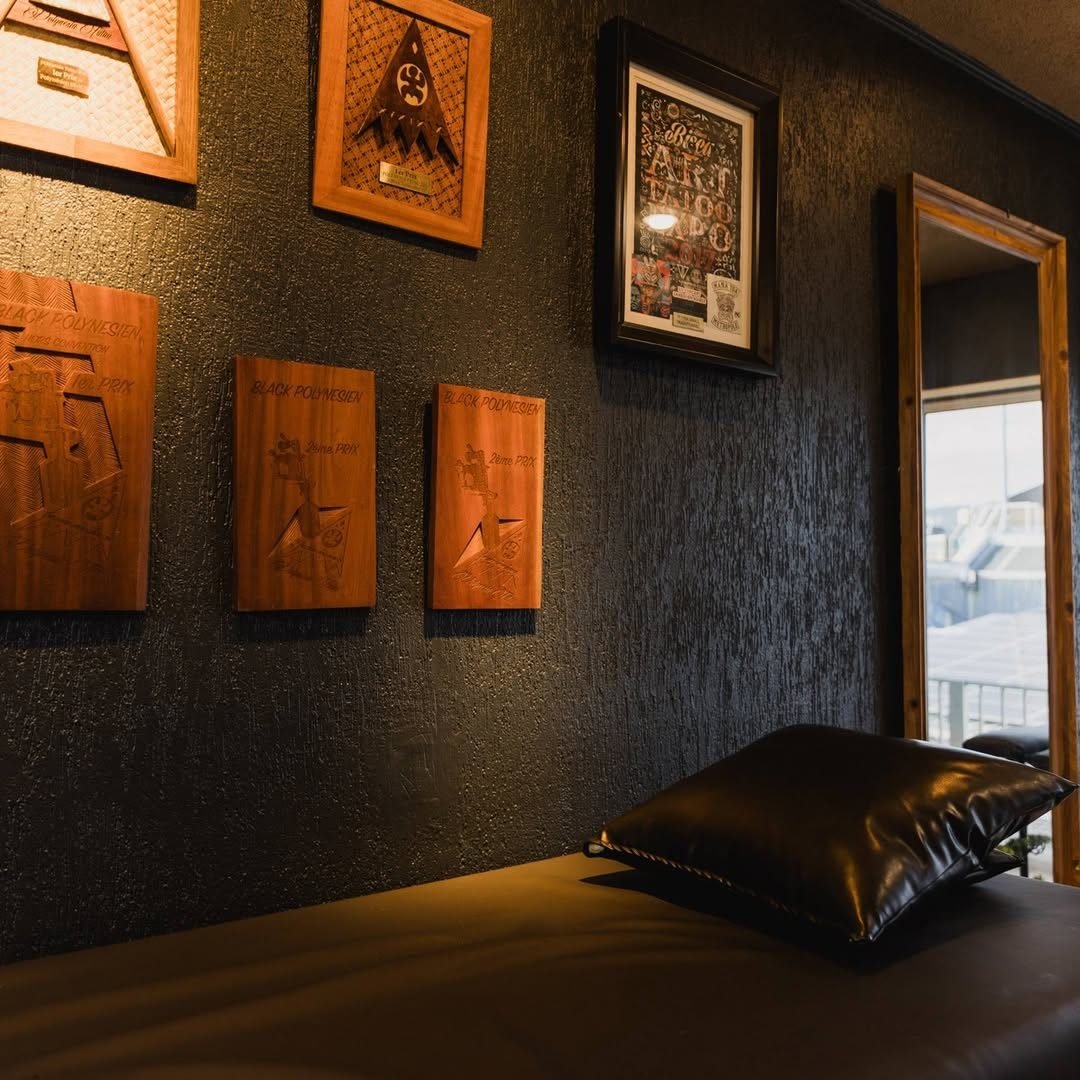 Intérieur du studio : table de soin en cuir, plaques sculptées au mur